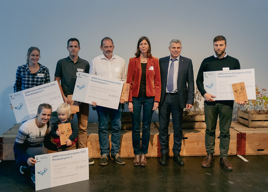 Regierungsrat Christoph Ammann und Co-Leiterin Anja Simma mit den glücklichen Siegerinnen und Sieger bei der Preisverleihung des Innovationswettbewerbs "Ideenpool KliWa".